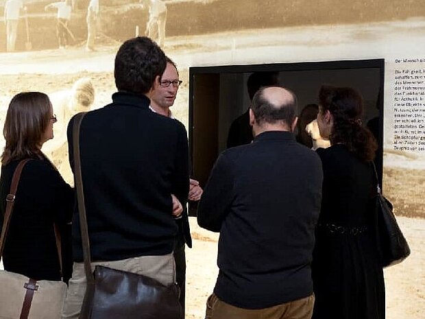 A scientist is guiding a group through the museum